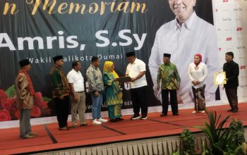 Foto : Pasangan calon nomor 2 Ferdiansyah, S.E dan H. Soeparto memberikan cinderamata kepada istri Alm. Amris.